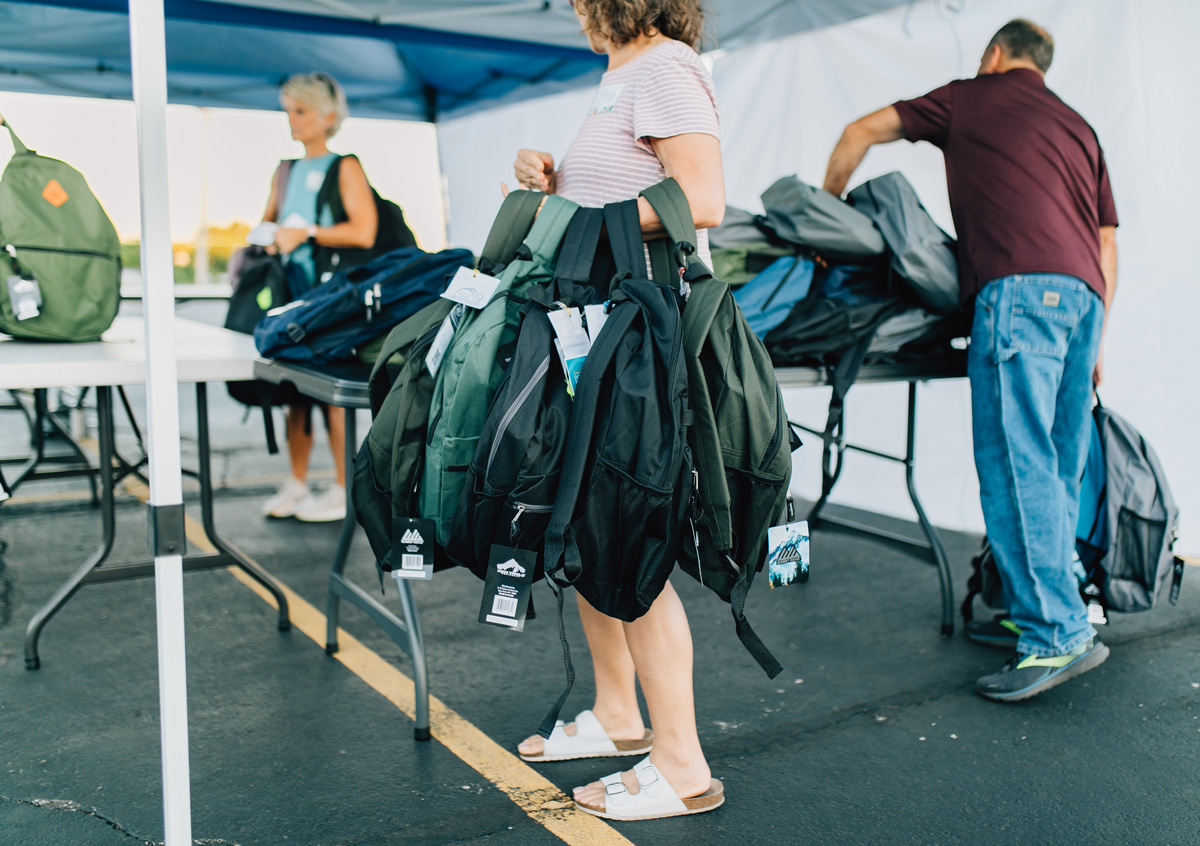 Volunteer Handing Out Free School Supplies