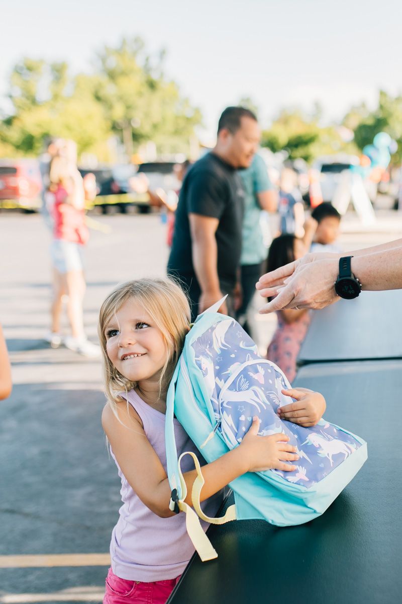Young Girl Receiving Free Backpack And School Supplies