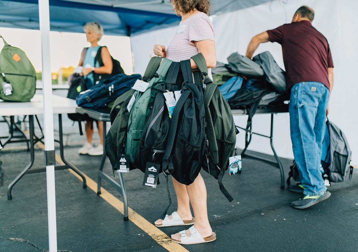 Volunteer Handing Out Free School Supplies